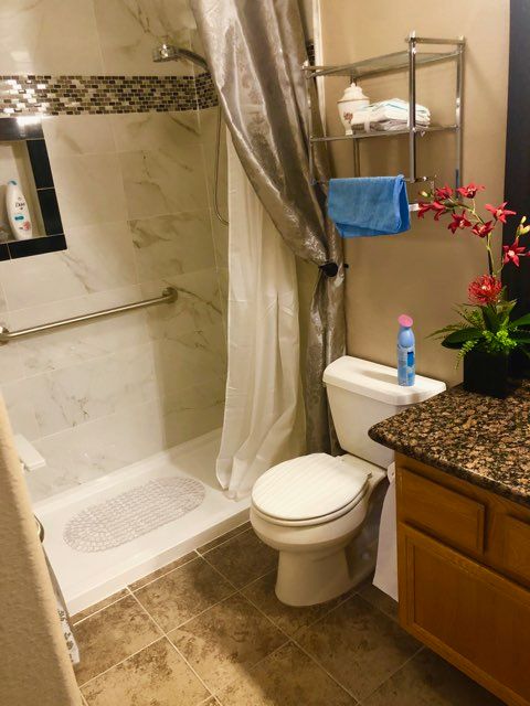 Senior resident in a spacious room with a bathroom, featuring a bathtub at Angel's Home Care.
