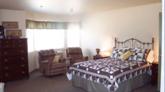 Interior view of a well-furnished bedroom at The Cottages of Meridian Senior Living Community.