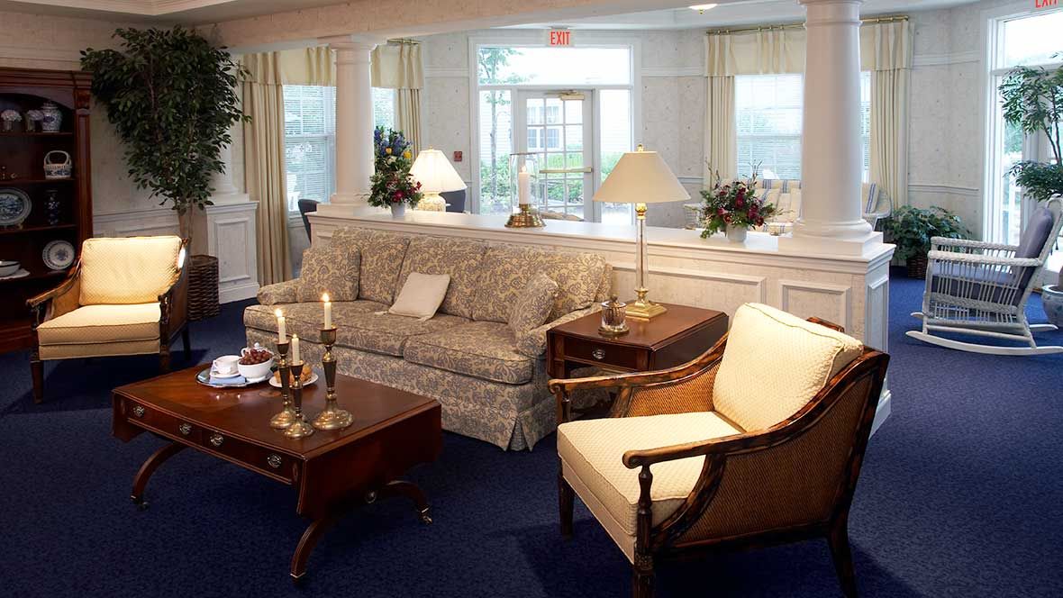 Senior living room at Atria Fairhaven featuring cozy furniture, home decor, and indoor plants.