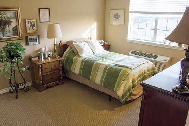 Senior living bedroom at Brookdale Round Rock with cozy furniture, table lamp, and home decor.