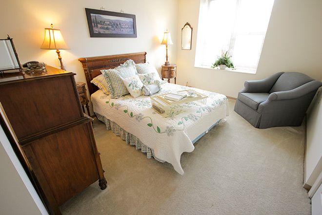 Senior living bedroom at Brookdale Southfield with bed, couch, laptop, and home decor.