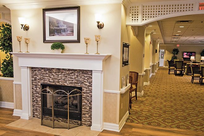 Interior view of Brookdale Orland Park senior living community featuring a cozy fireplace, stylish furniture, and modern electronics.