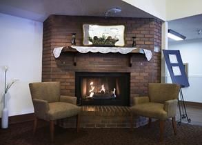 Interior view of Sunny Ridge Senior Living room with fireplace, furniture, and architecture.