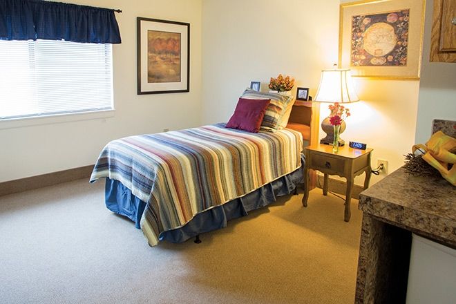 Interior design of a bedroom at Brookdale Echelon Lake senior living community featuring art, furniture, and decor.
