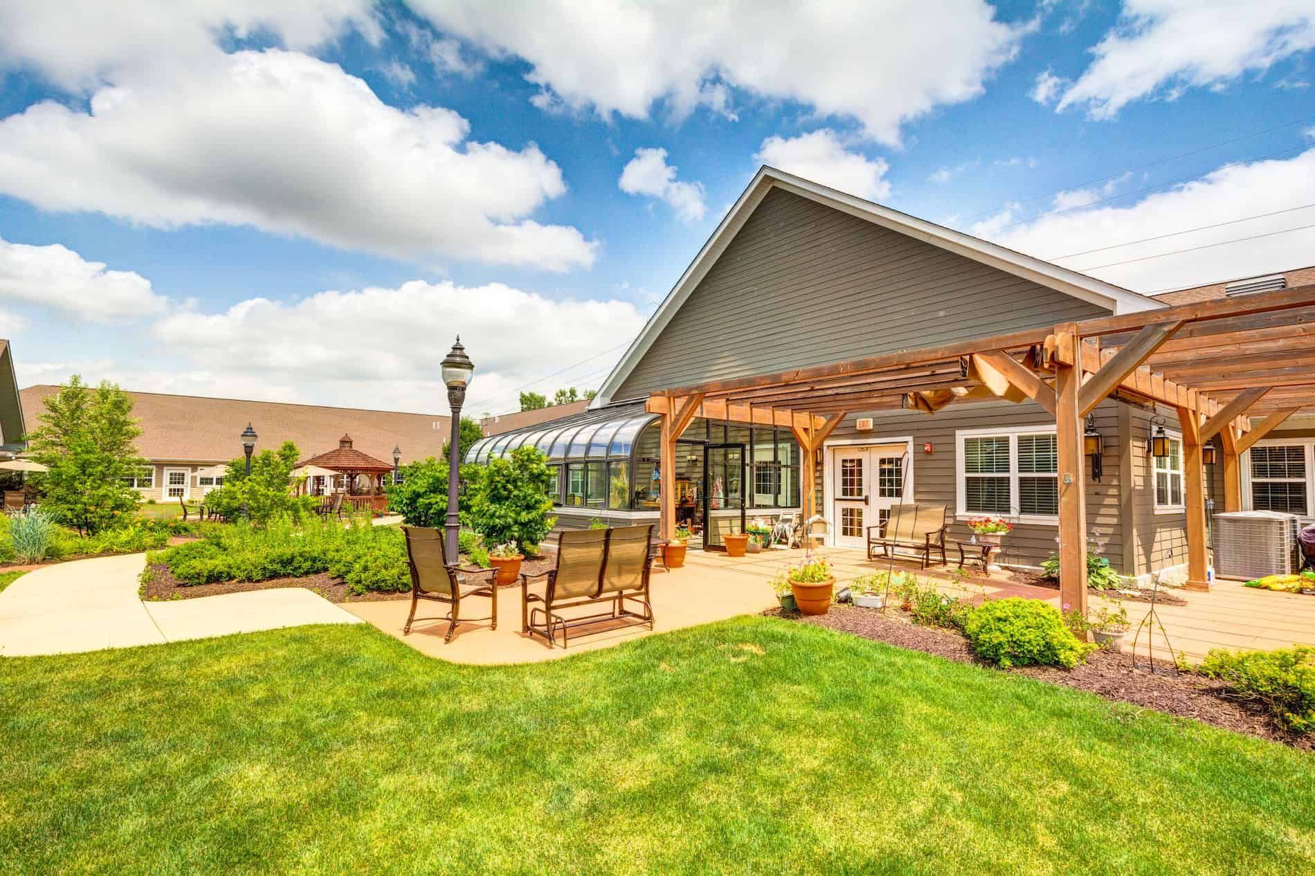 Senior living community, Auberge At Naperville, featuring elegant architecture and lush backyard.
