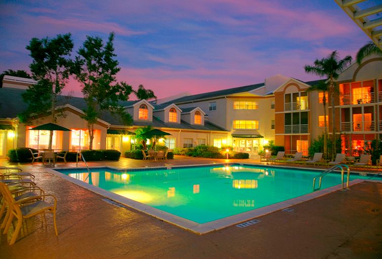 Senior living community, Coral Oaks, featuring resort-style architecture, pool, and waterfront villas.