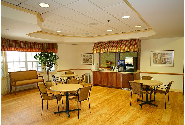 Interior view of Coral Oaks senior living community featuring hardwood flooring and furniture.