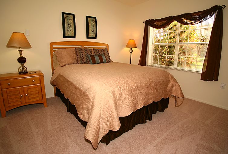 Interior view of a well-furnished bedroom at Coral Oaks senior living community.
