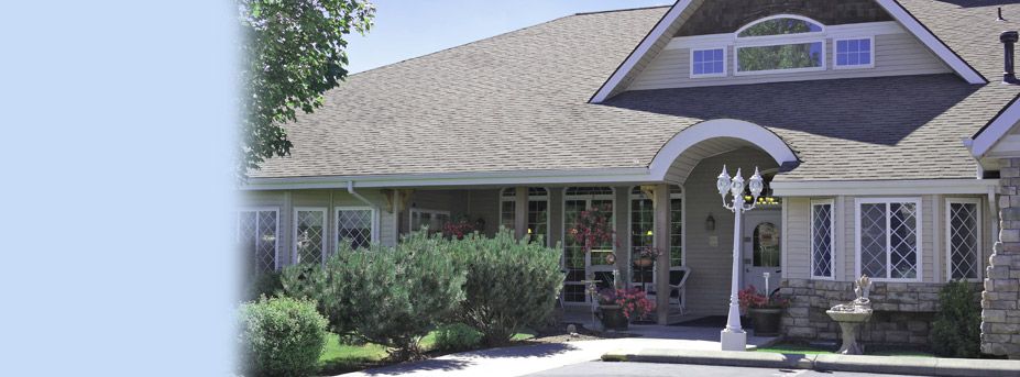 Senior living community, Guardian Angel Homes, featuring a cottage-style house with a portico entrance.