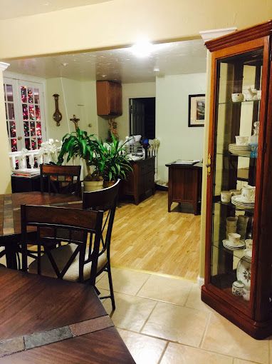 Interior view of Jewel Lake Assisted Living Home featuring dining room with wooden furniture.
