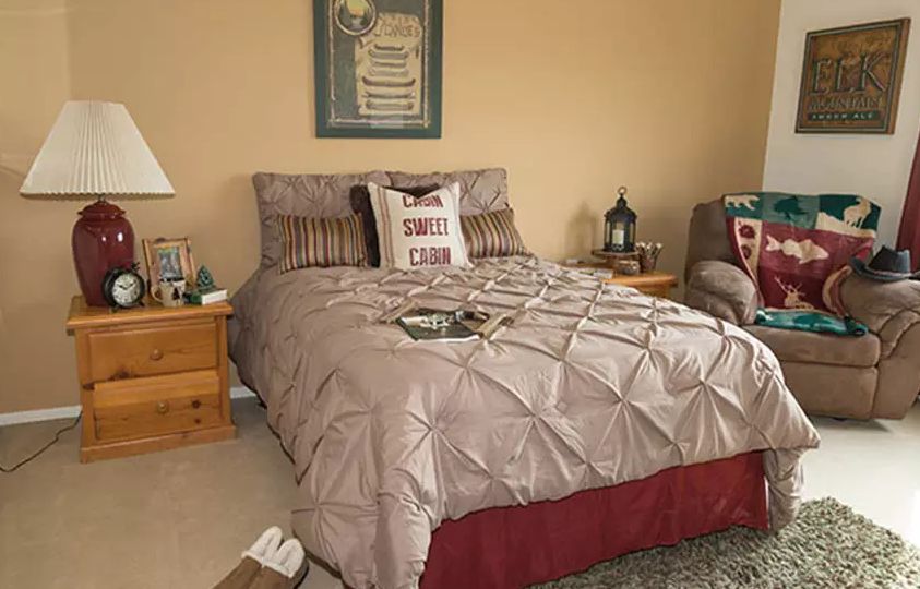 Senior living community at Westminster Terrace featuring furniture, home decor, and a cozy bed.
