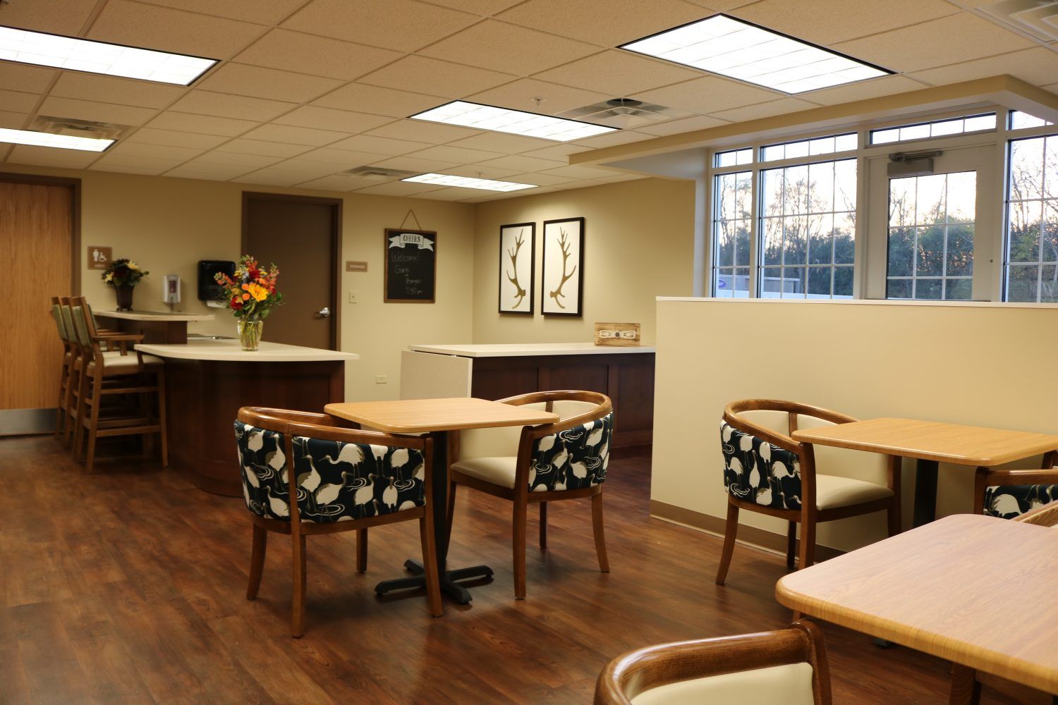 Interior view of Lacey Creek Supportive Living's dining area with wooden furniture and art decor.