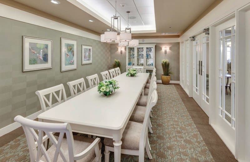 Senior living community Merrill Gardens at Huntington Beach featuring dining room with elegant furniture and decor.