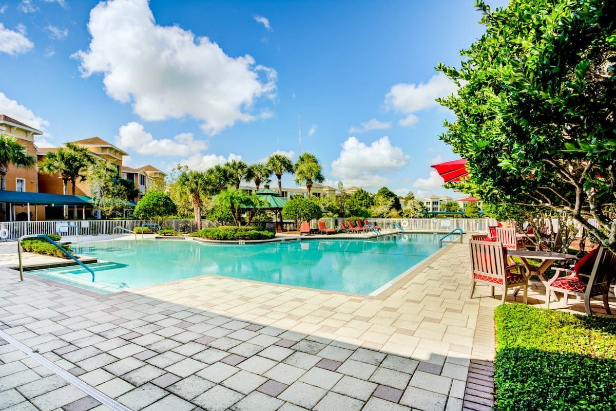 Senior living community Aston Gardens At Tampa Bay featuring resort-style villas, pool, and scenic outdoors.
