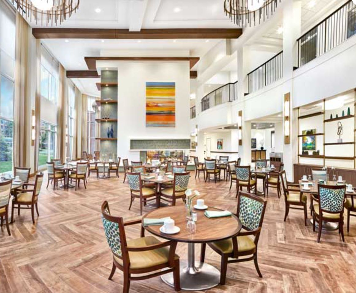 Interior view of Oak Trace senior living community featuring dining area, cafe, and lounge.