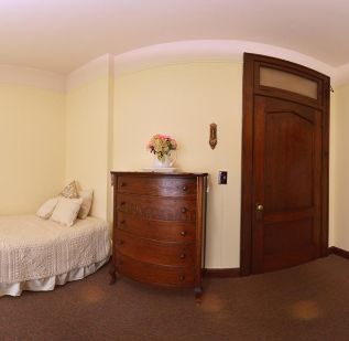 Interior view of Hume Home of Muskegon senior living community featuring hardwood furniture and decor.