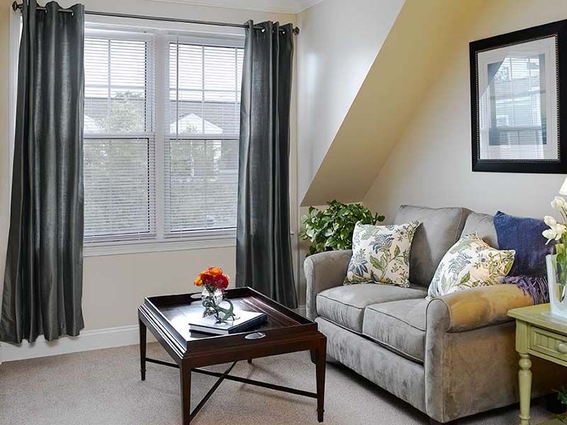 Senior living room at Atria Aquidneck Place with cozy furniture and modern home decor.