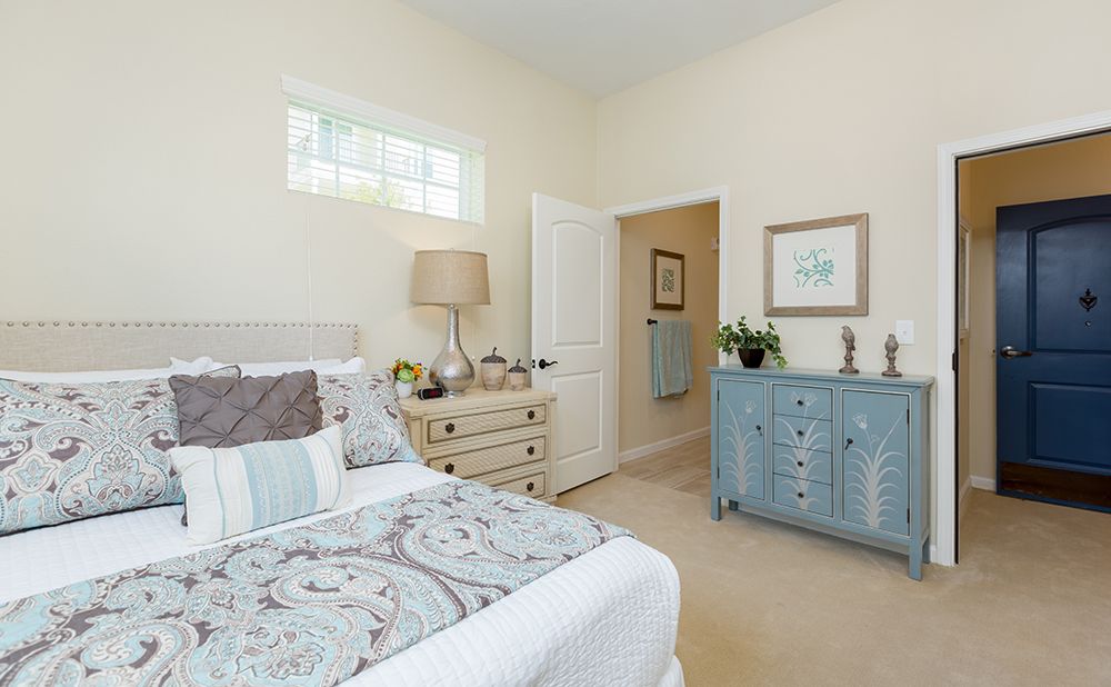 Corner bedroom with elegant furniture and decor at The Enclave at Cedar Park Senior Living.