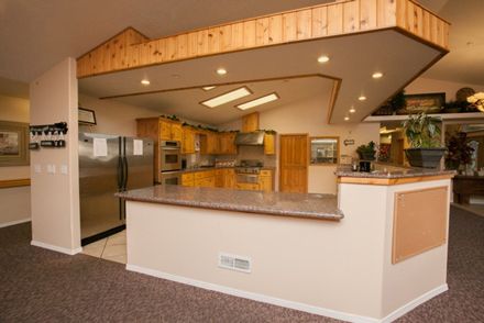 Interior view of Caring Hearts Assisted Living community kitchen with modern furniture and design.