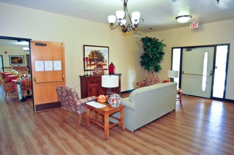 Spacious living and dining area in Boulder Gardens Assisted Living, featuring hardwood floors and elegant decor.