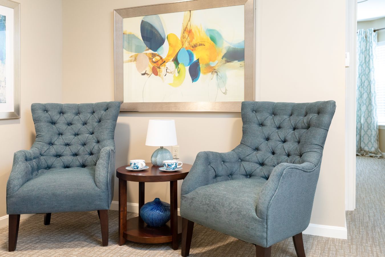 Artistic interior of New Pond Village senior living community featuring furniture, paintings, and armchairs.