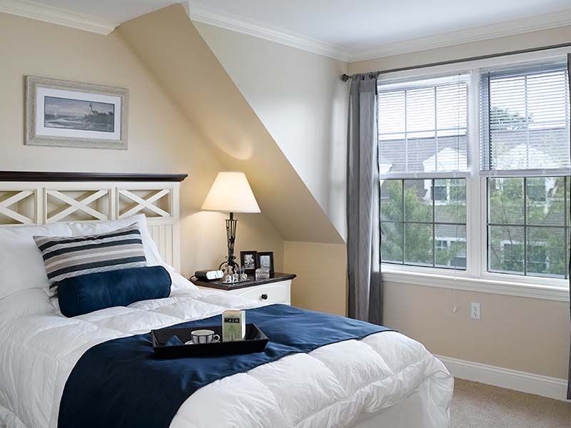 Senior enjoying a cozy bedroom with elegant interior design at Atria Aquidneck Place.