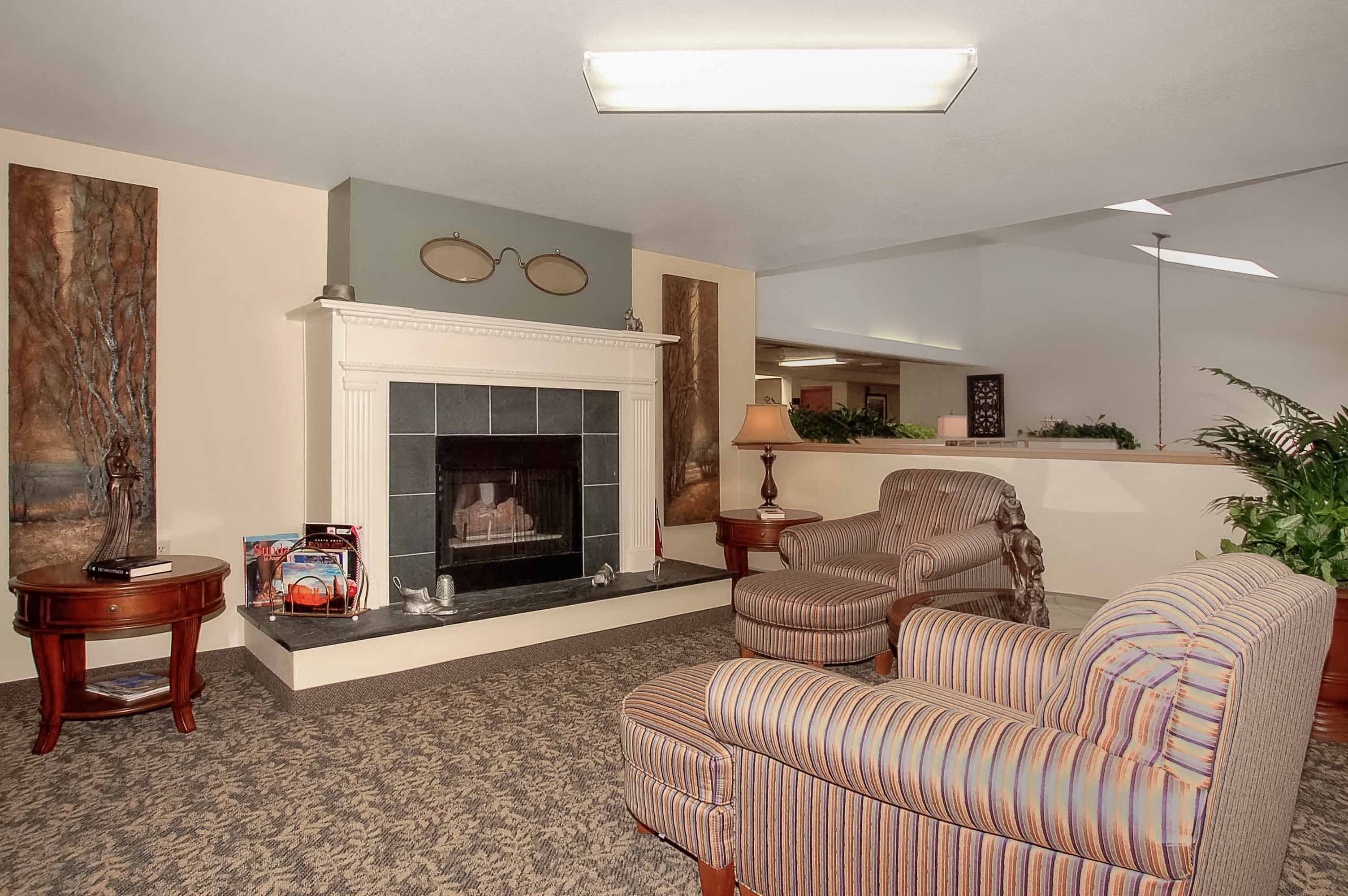 Interior view of Parkwood Estates senior living community featuring elegant decor, fireplace, and furniture.