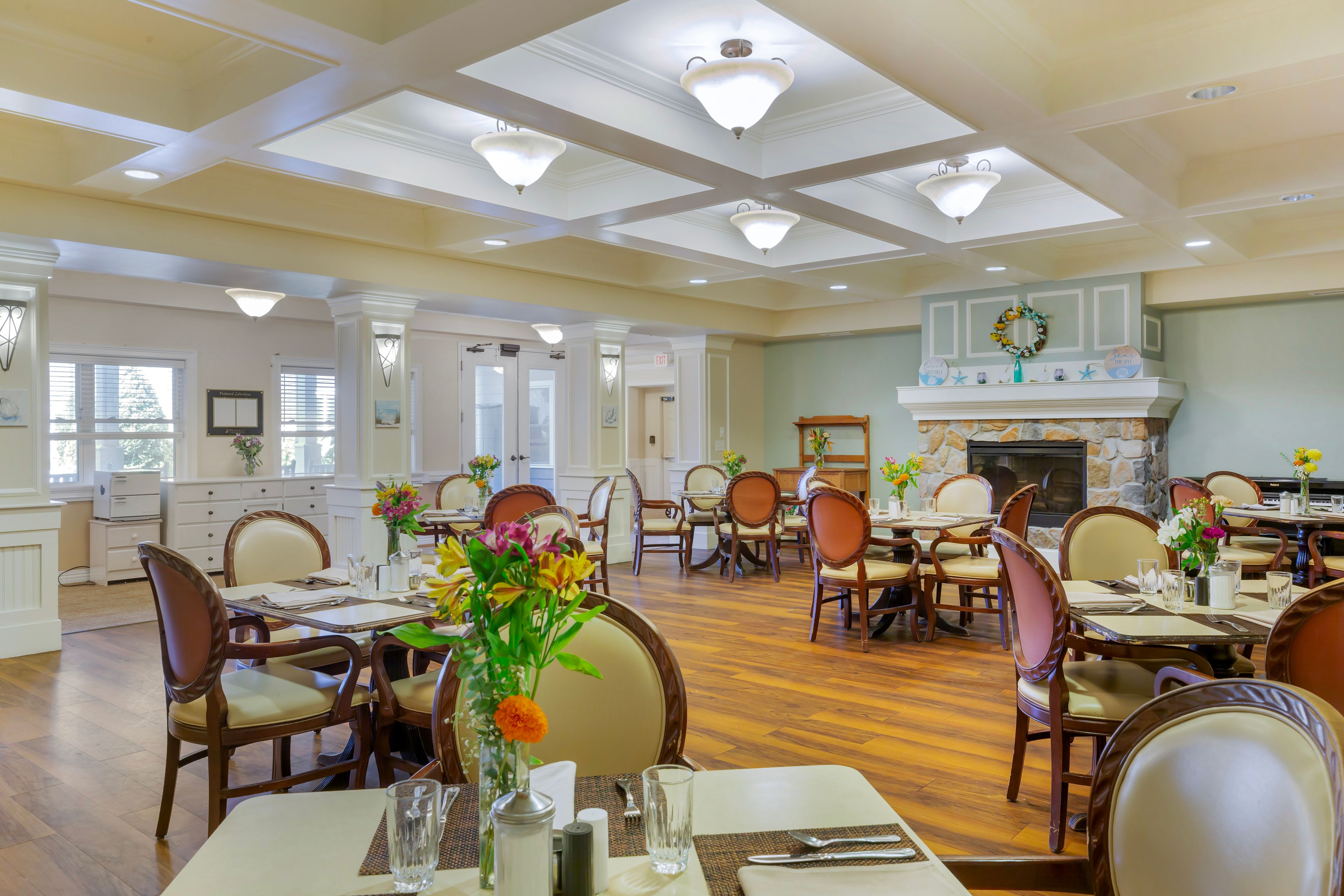 Interior view of Brookdale Centre of New England's dining area with wooden furniture and floral decor.