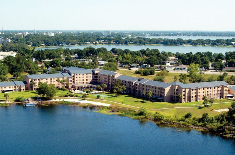 Aerial view of Spring Haven senior living community with scenic lakefront and architectural buildings.