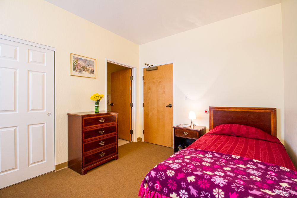 Interior view of a well-furnished bedroom at Burlingame Villa senior living community.