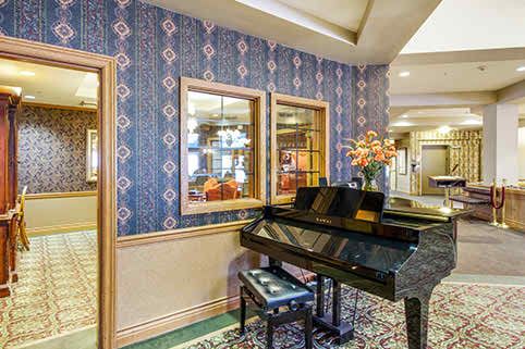 Interior view of Fairwinds Ivey Ranch senior living community featuring a grand piano and home decor.