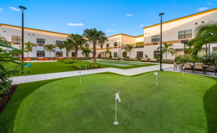 Senior living community, Inspired Living Royal Palm Beach, featuring villas, golf course, and lush greenery.