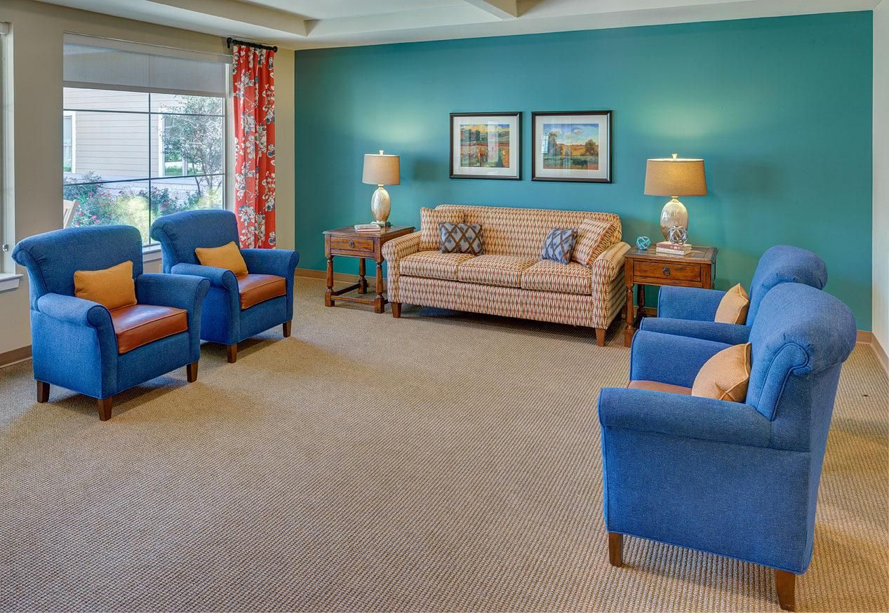 Senior living room at The Delaney At Georgetown Village with cozy furniture and decor.