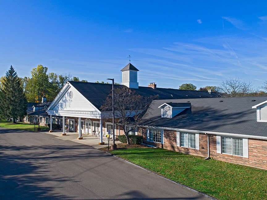 American House Livonia, a senior living community with beacon tower in a suburban neighborhood.