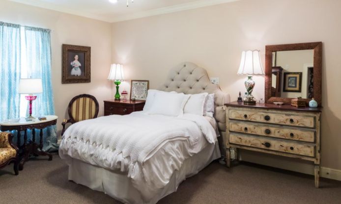 Senior resident relaxing in a well-furnished bedroom at Summerfield Senior Living in Gulfport.
