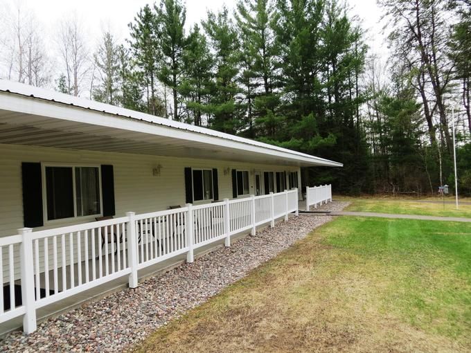 Senior living community, Country Terrace Rhinelander, featuring outdoor yard with trees, plants, and picket fence.