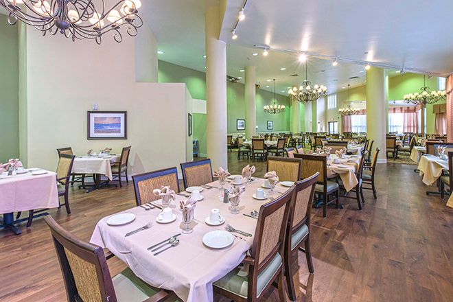 Senior living community dining room at Brookdale Palm Beach Gardens with elegant furniture and decor.