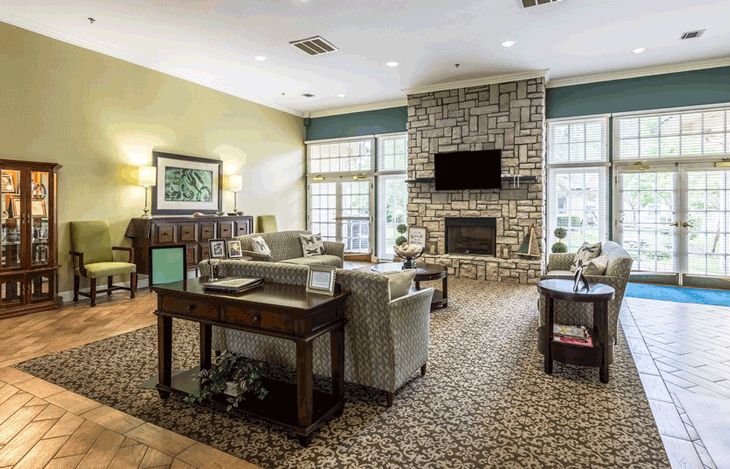 Interior view of American House Bartlett senior living room with modern furniture and electronics.