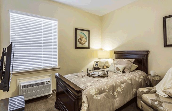 Interior design of a bedroom in American House Bartlett senior living community with modern furniture.