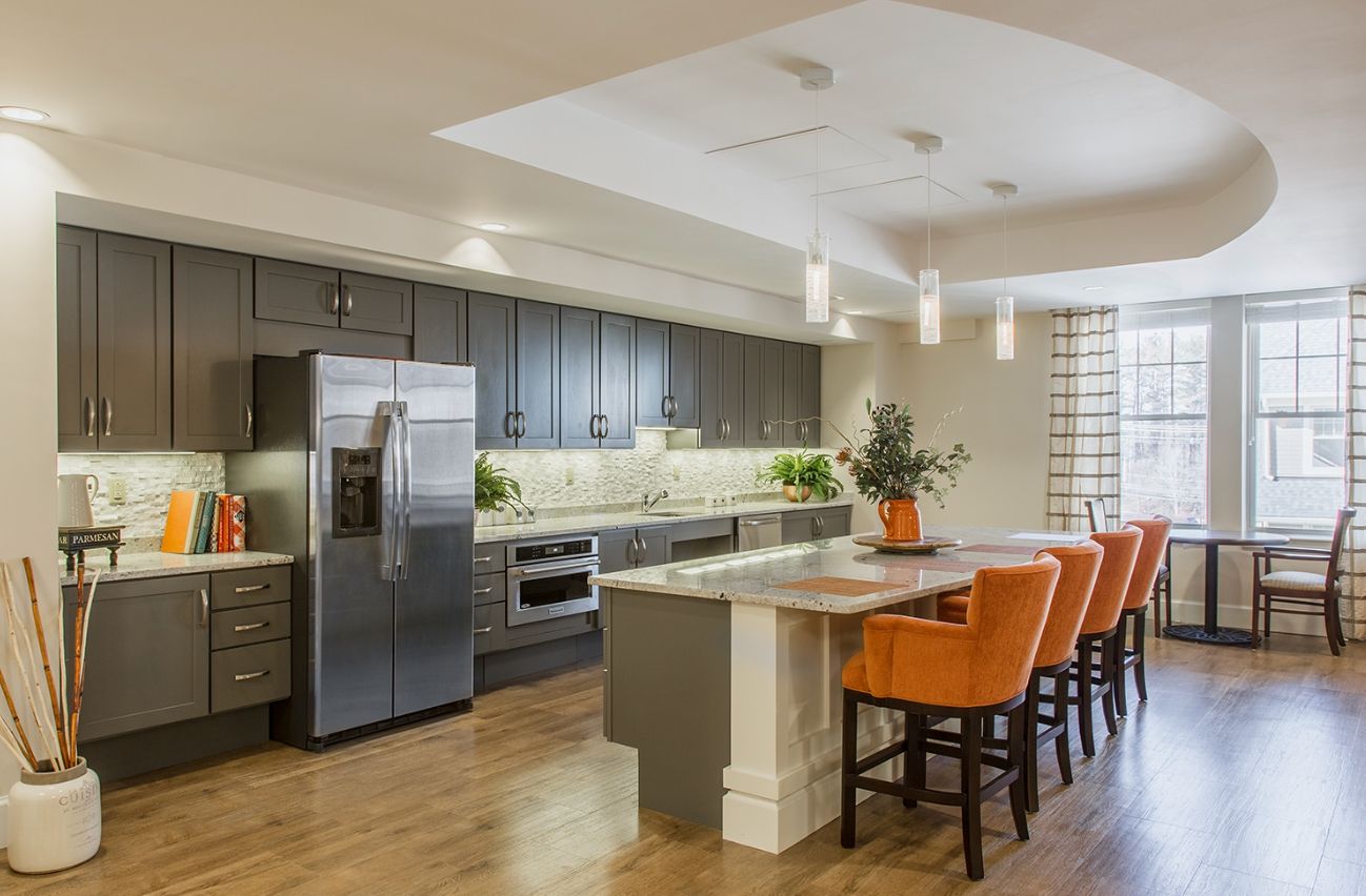 Interior view of The Residence At Five Corners senior living community featuring a modern kitchen and dining area.