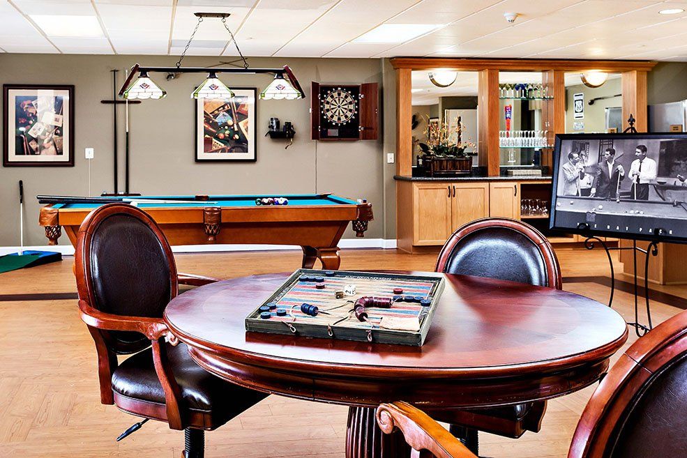 Senior resident enjoying billiards in the well-furnished interior of MorningStar Sparks community.