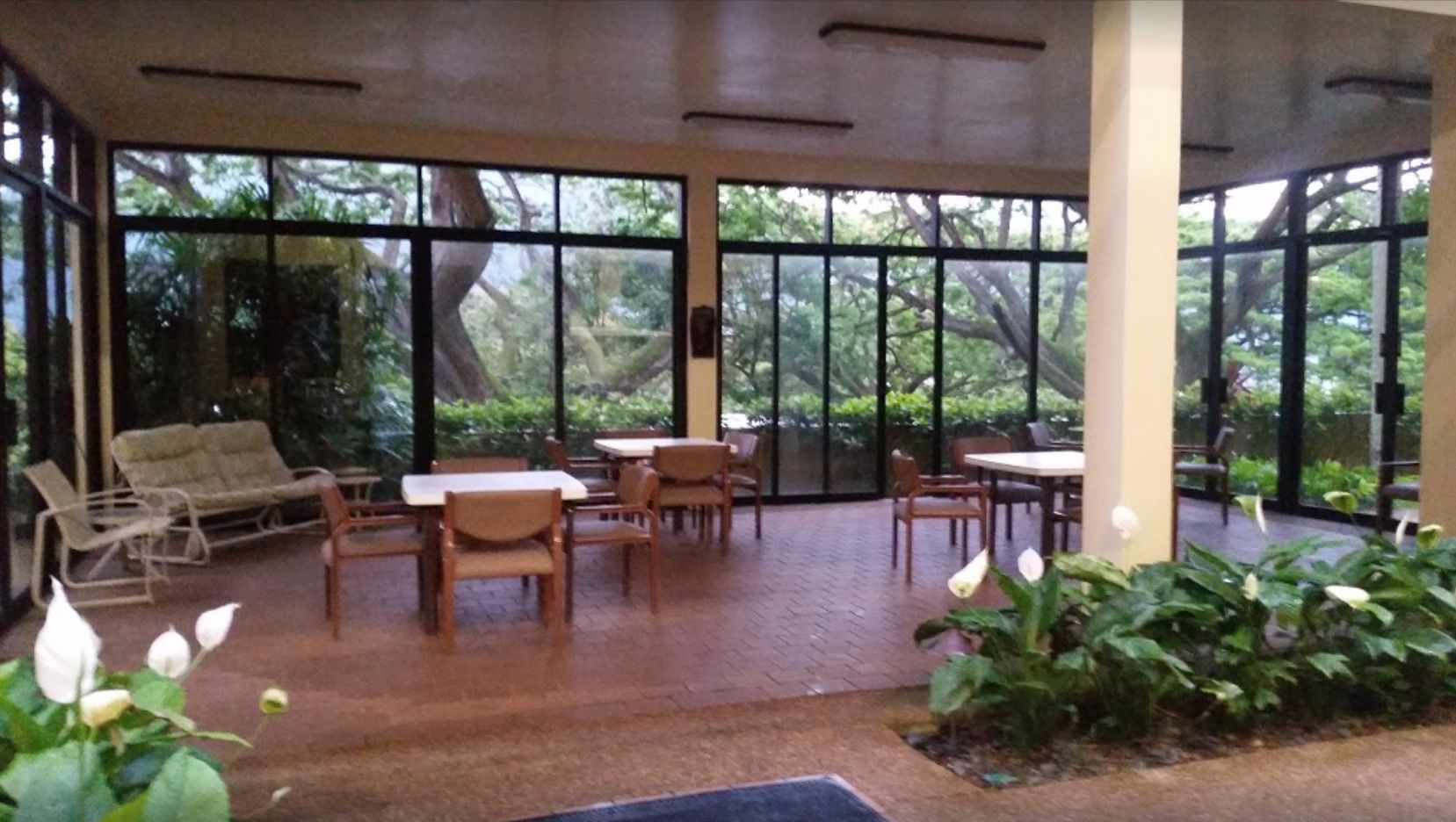Senior living community Pohai Nani featuring tennis sport, indoor and outdoor furniture, and lush nature.