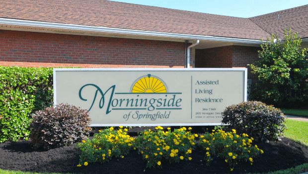 Plant and flower-filled Morningside of Springfield senior living community with its hotel-like architecture.