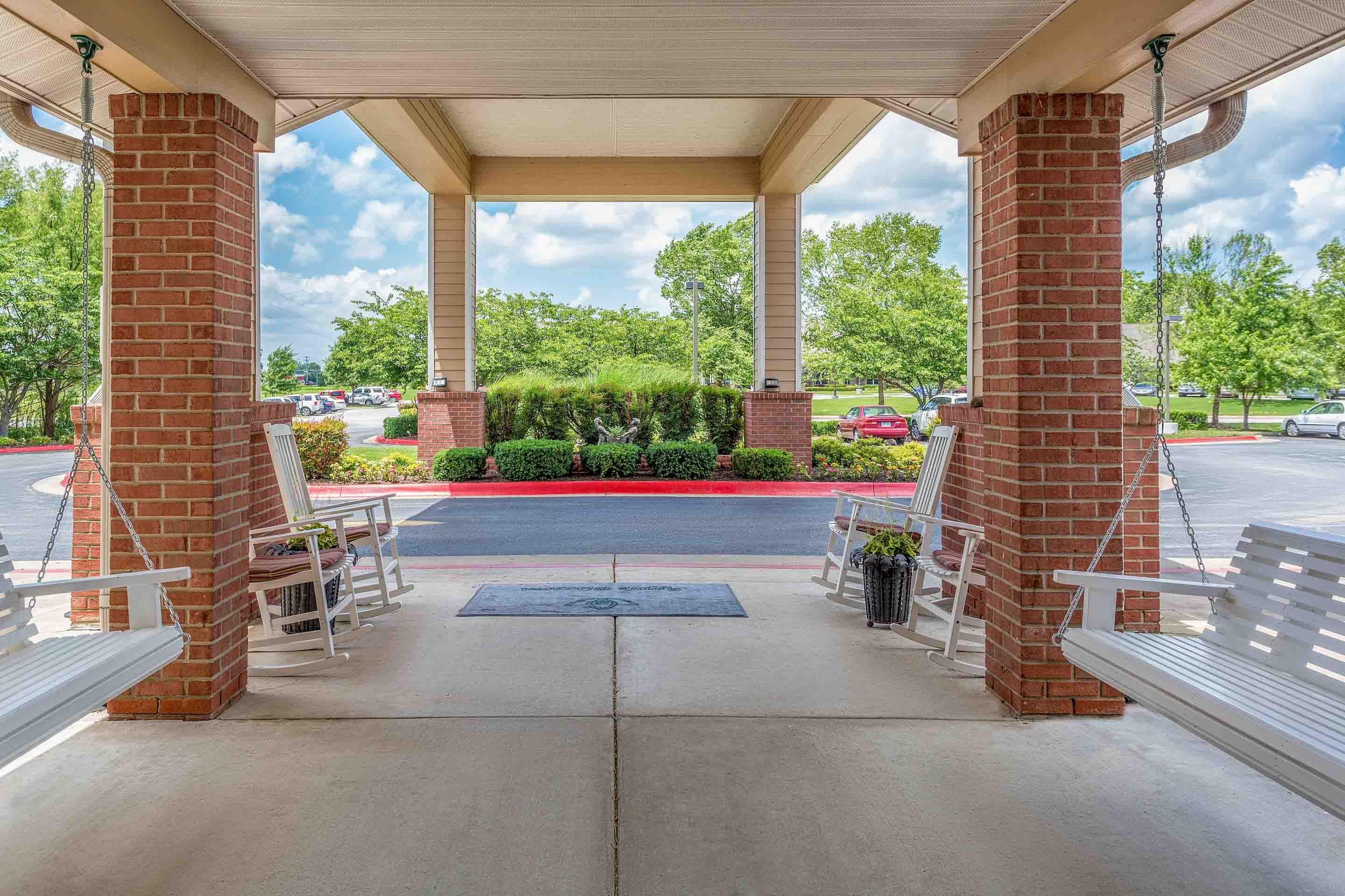 Senior living community Morada Rogers featuring houses, porch, outdoor benches, and cars.