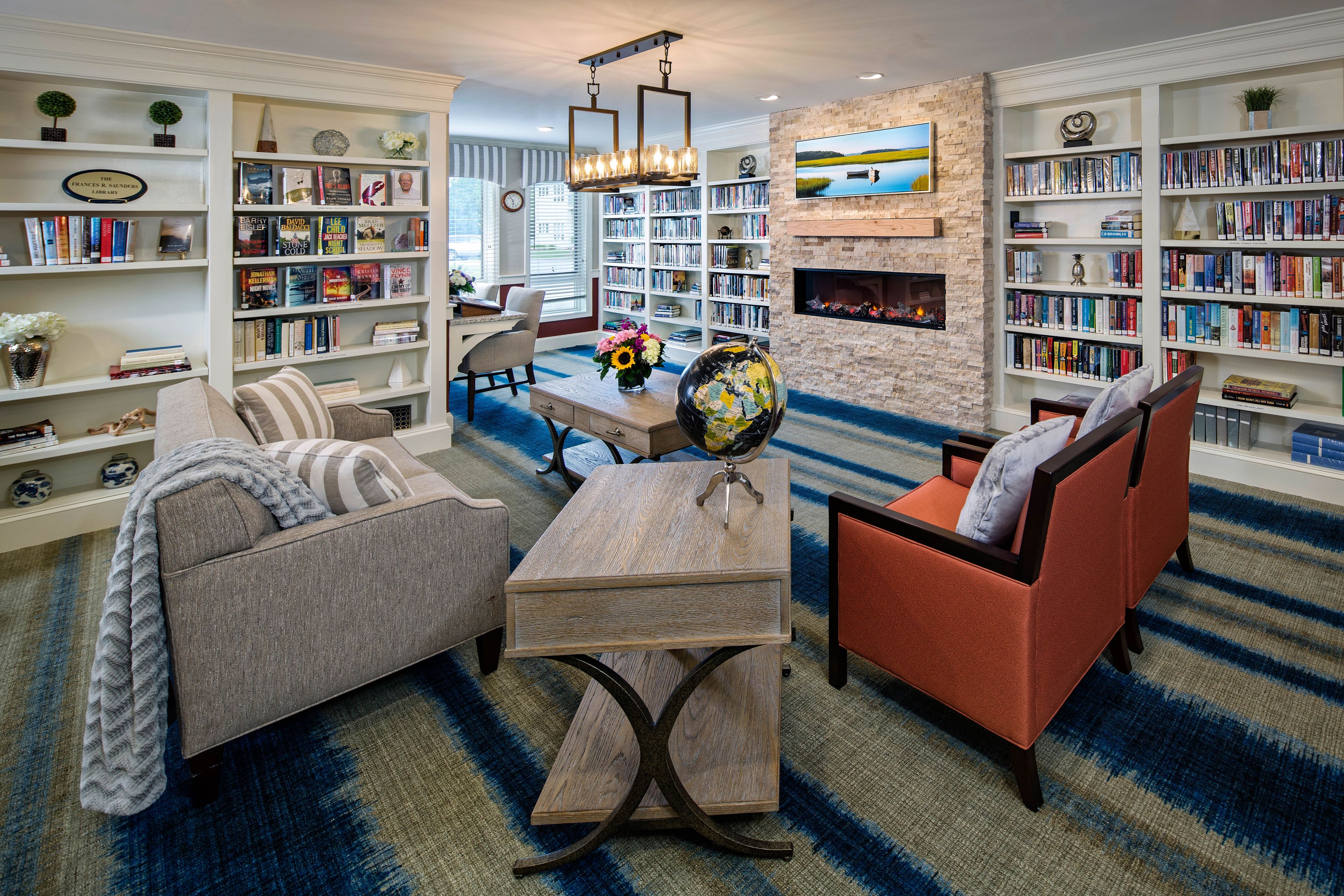 Senior living room at Maplewood at Mayflower Place with cozy furniture and library.