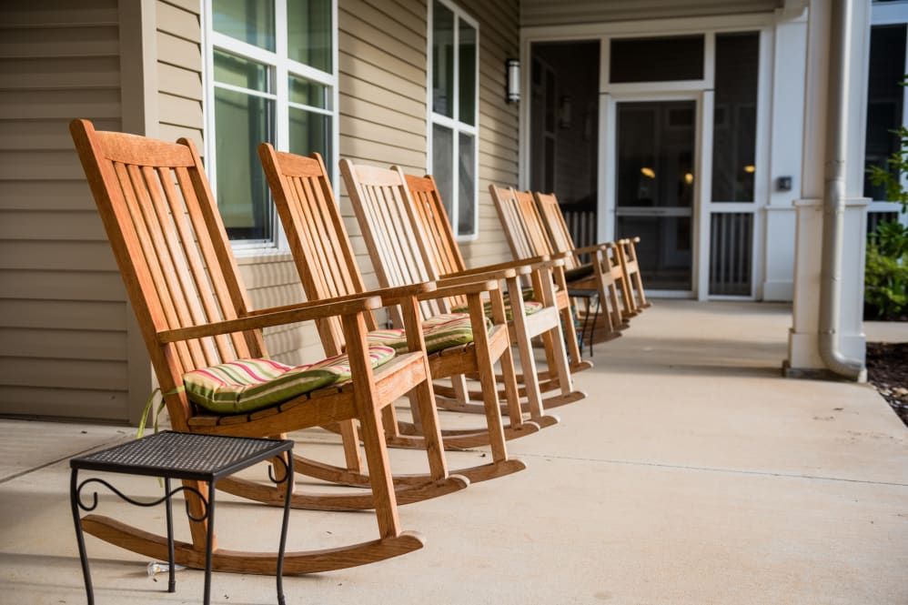 Senior living community Avenir Memory Care at Fayetteville featuring house, porch and furniture.