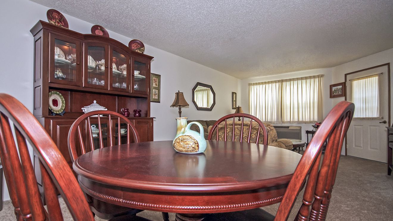 Senior living community interior featuring dining room with hardwood furniture and elegant design.