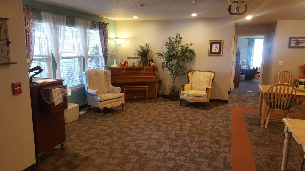 Senior residents enjoying in the spacious, well-decorated reception room at Country Time Assisted Living.