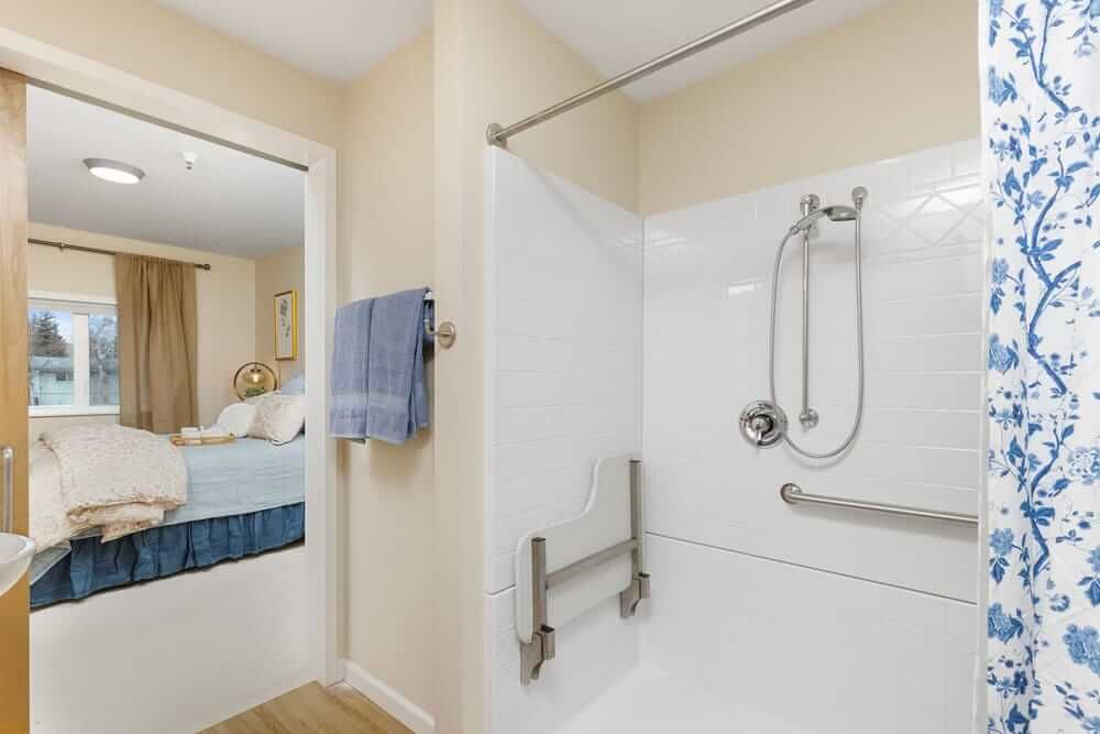 Interior view of Baxter Senior Living featuring a well-designed bedroom and bathroom with modern furniture.