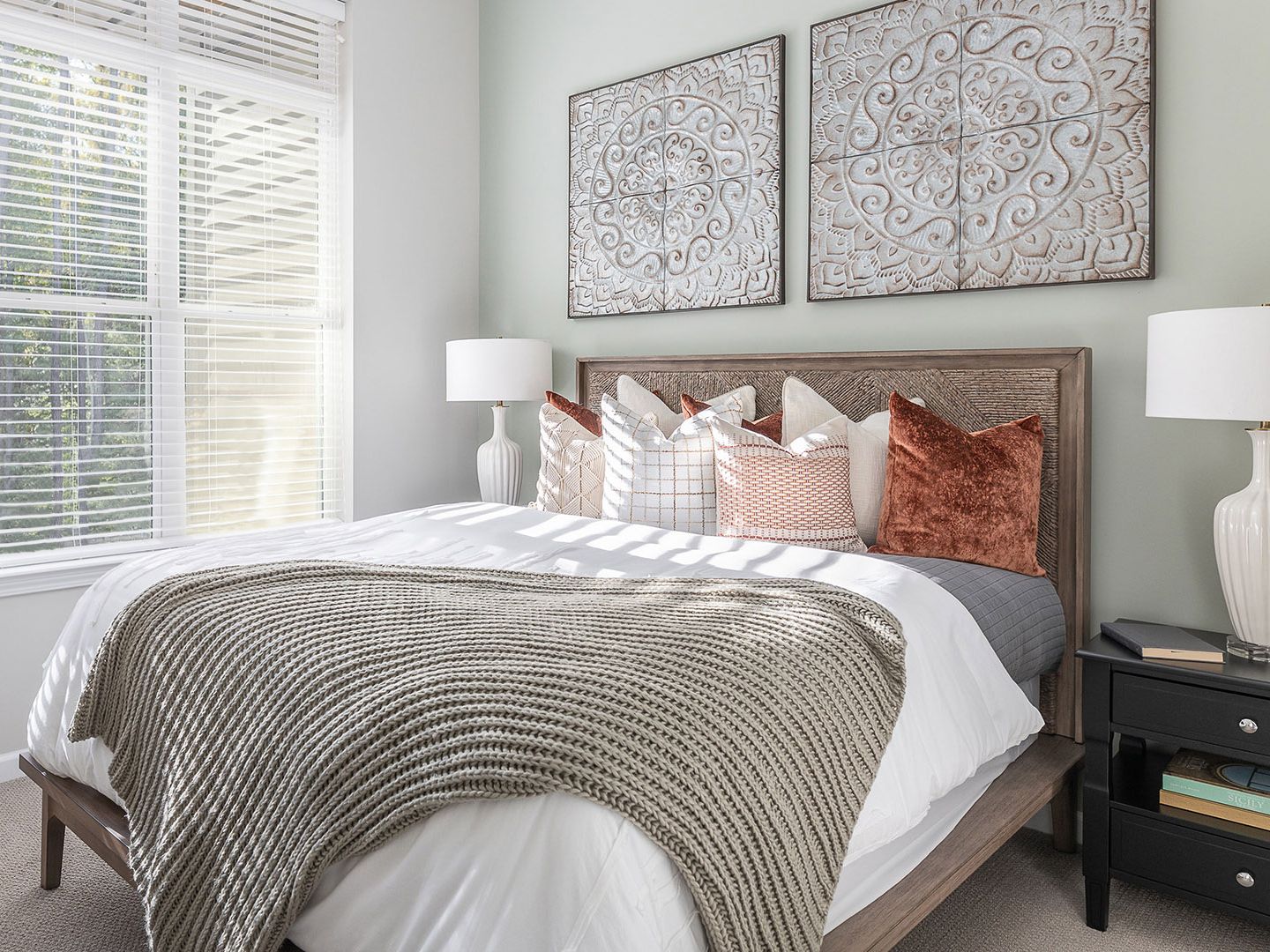 Interior design of a bedroom at Atria Draper Place senior living community with bed, furniture, and decor.